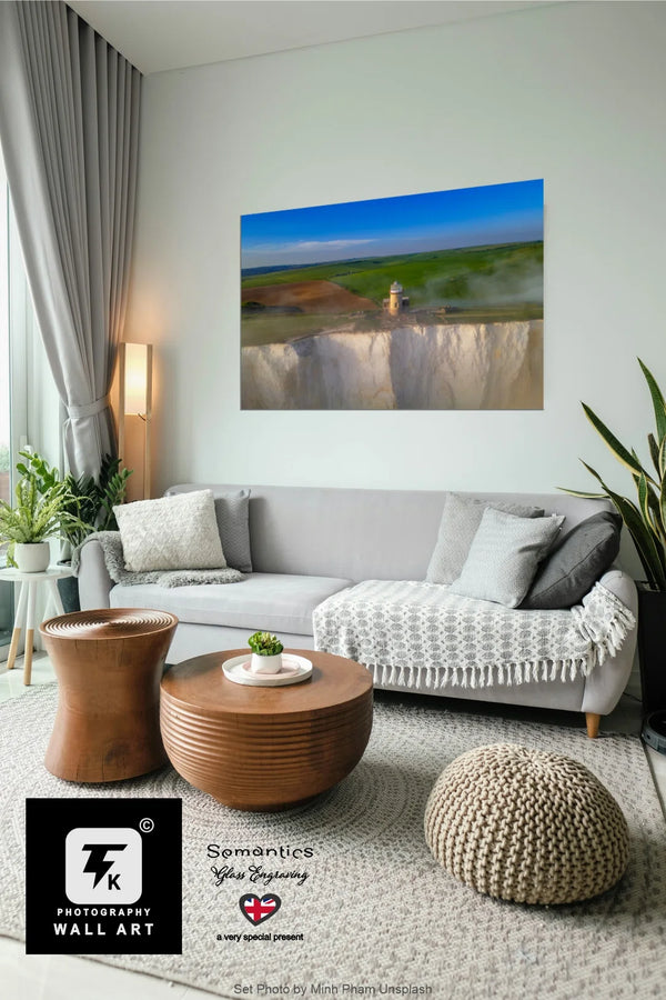 Living room with a gray sofa, wooden coffee table, and a large wall art print of a scenic landscape, Belle Tout Cliff.