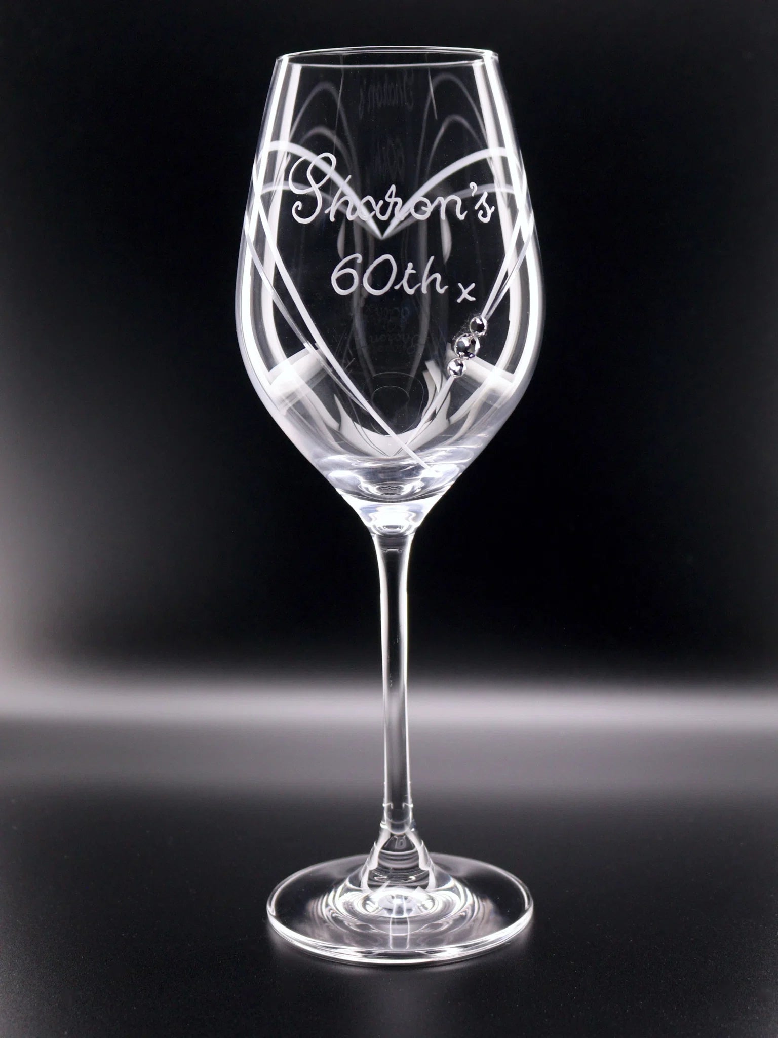 A glass with a heart cut into the glass with Diamante Stones frames stylish hand engraved Sharon's 60th